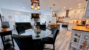 A modern kitchen with white cabinets, a wooden island, and a built-in oven. - 37PA Superbly appointed riverfront home in LIttleton! Skiing, hiking, firepit, wifi, dog friendly! (Littleton)