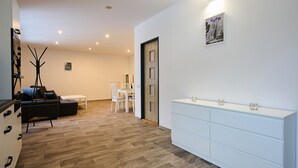A modern living room with a sofa, a dining table, and a white cabinet. - U Dzina by Interhome (Desná v Jizerských horách)