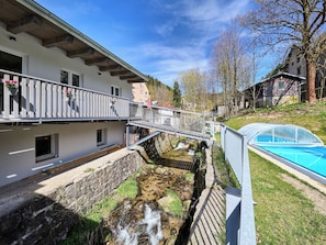 A building with a balcony, a small stream, and a swimming pool. - U Dzina by Interhome (Desná v Jizerských horách)
