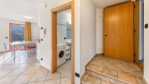 A modern interior with a dining area, a washing machine, and a wooden door.