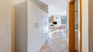 A hallway leading to a room with a desk, chair, and a view of mountains.