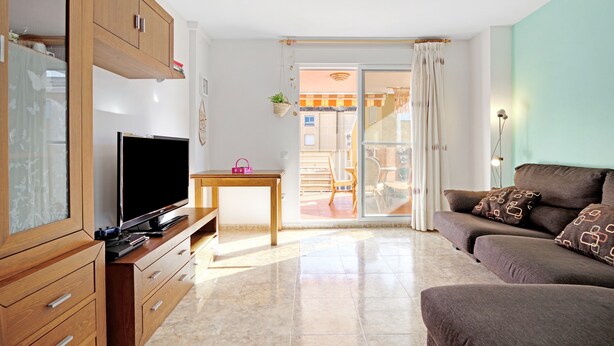 Ein Wohnzimmer mit Fernseher, Sofa und Holzsäcken.