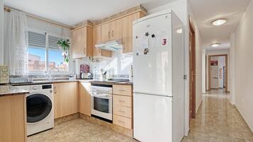 Eine Küche mit Waschmaschine, Backofen und Kühlschrank.