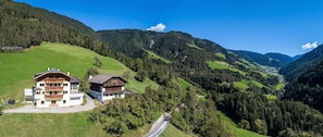 A mountain landscape with a building featuring balconies and a road.