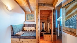 Een houten interieur met een bank, een lijst met foto en een raam met uitzicht.