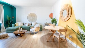 A modern living room with a green sofa, a round wooden table, and a yellow accent wall. - Milo Apt - Trastevere's Gem (Roma)
