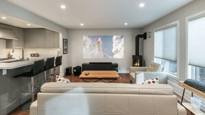 Un salon moderne avec un canapé, une table basse et une cheminée.