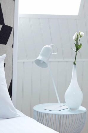 A white bedside table with a white lamp and a white vase with white flowers. - LE 64, Chambre Bois DES Combles (EU)