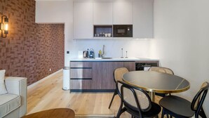 A modern kitchen with a central island, white cabinetry, and a built-in microwave. - 11.Appart 4Pers#1 Bedroom #Père Lachaise #Nation (Paris)
