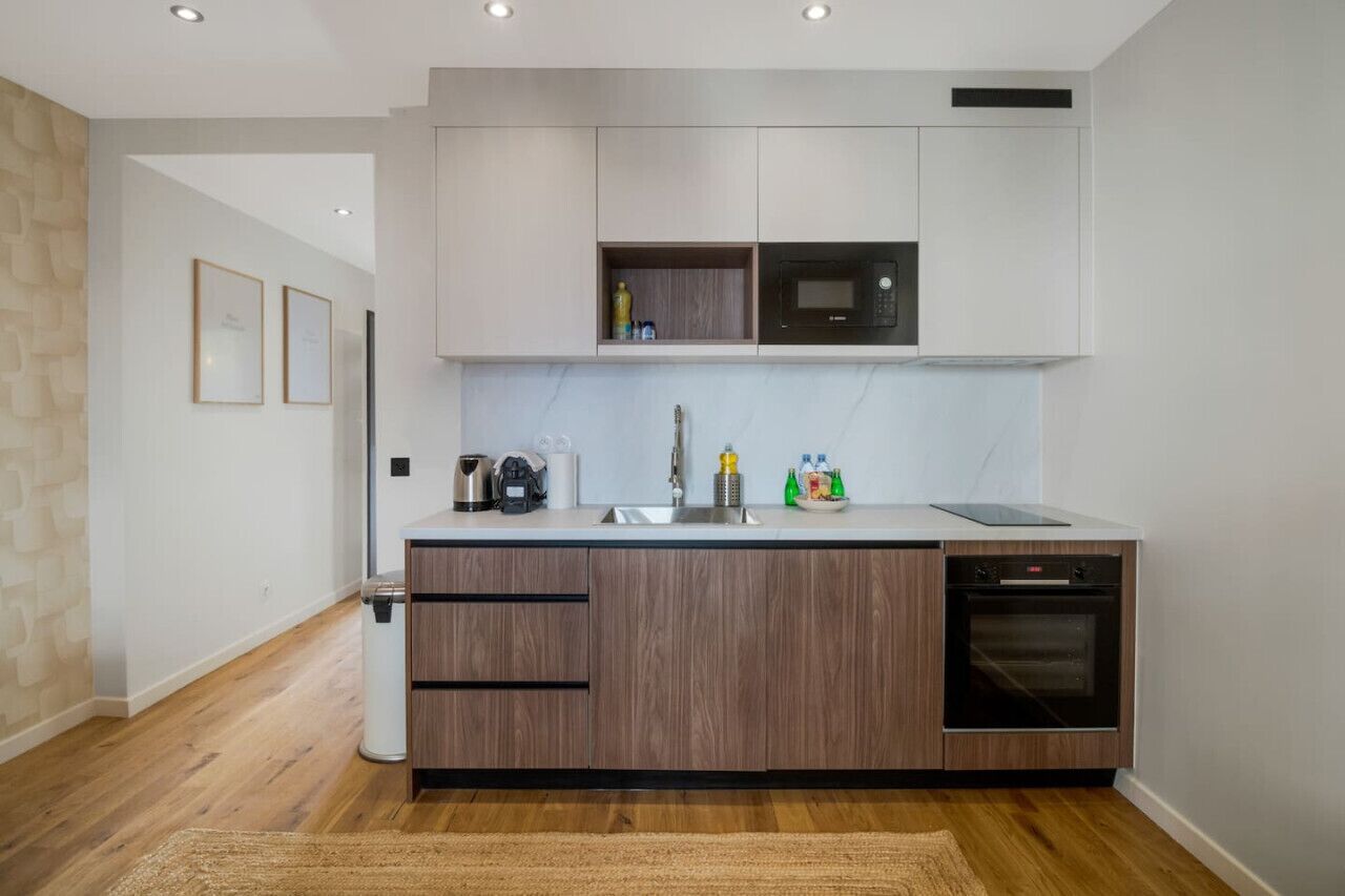 Una cocina moderna con armarios de madera, microondas integrado y lavavajillas.