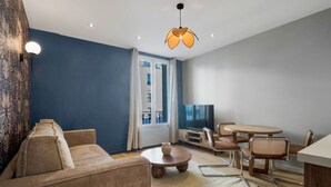Ein modernes Wohnzimmer mit einer Couch, einem Couchtisch und einem Essbereich mit Stühlen und einem Tisch.