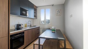 Une cuisine compacte dotée d’appareils électroménagers modernes, une table à manger et une fenêtre offrant une vue agréable.