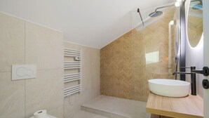 Une salle de bain moderne équipée d’une douche, de toilettes et d’un lavabo.