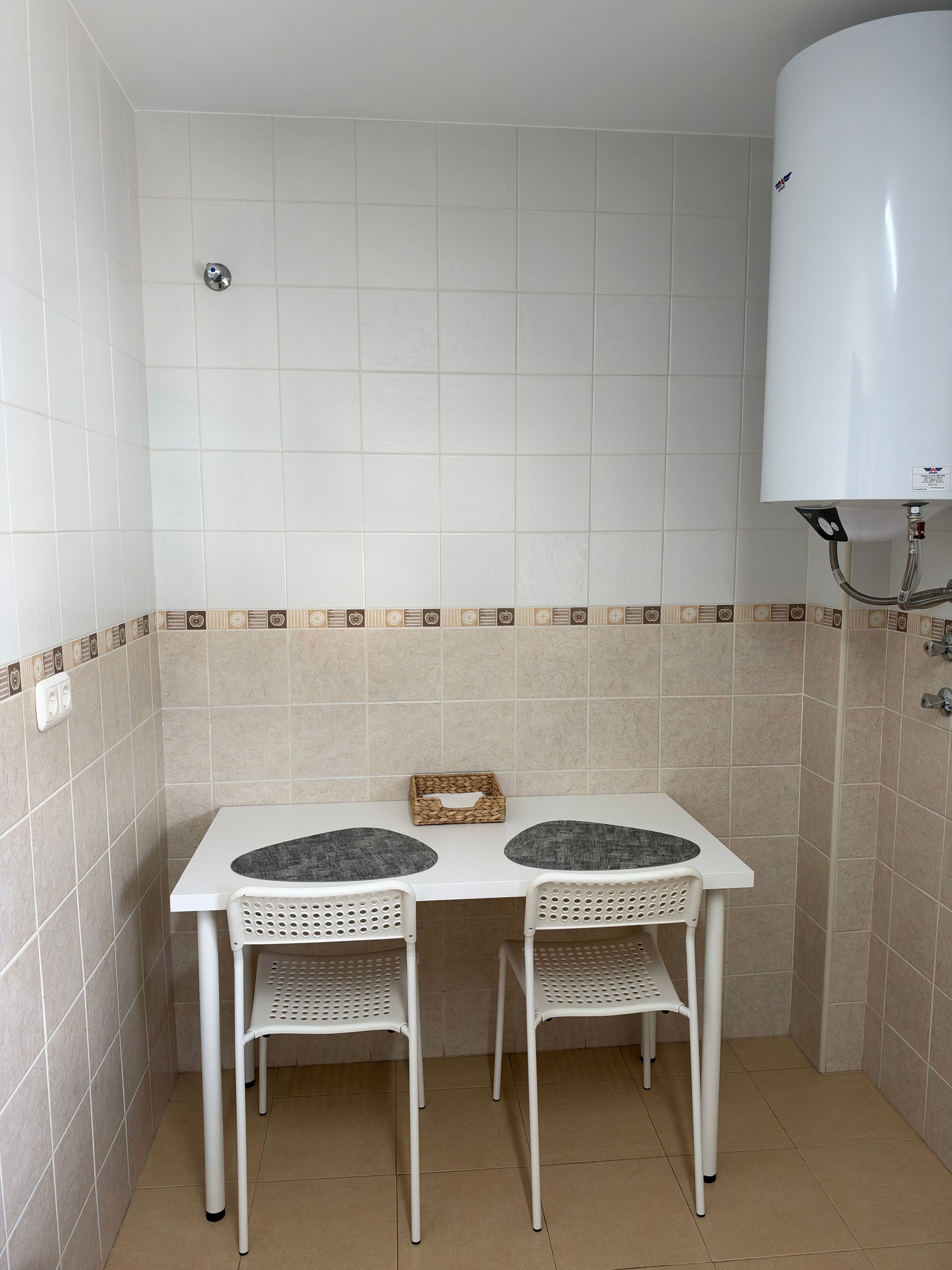 Un bagno piccolo con un lavandino bianco, due sedie e un WC bianco.