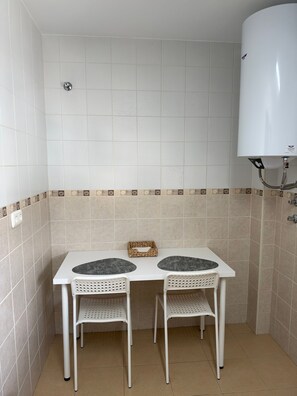 Un bagno piccolo con un lavandino bianco, due sedie e un WC bianco.
