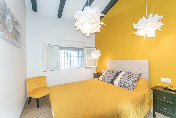 A bedroom with a bed, a chair, and two hanging light fixtures. - Villa 'Casa Chatsee' with Mountain View, Wi-Fi and Air Conditioning (Torrox)