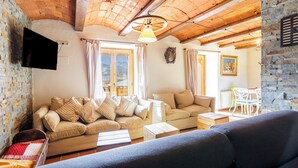Ein gemütliches Wohnzimmer mit einem beigefarbenen Sofa, einem blauen Couch und einem Holztisch.