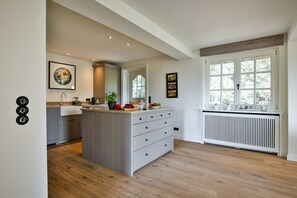 A modern kitchen with a central island, built-in appliances, and a window with a view.