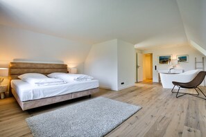 A bedroom with a bed, a chair, and a desk area.