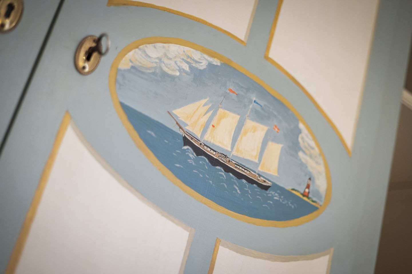 A door with a maritime-themed design, including a sailboat and waves.
