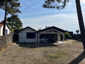 A two-story house with a covered patio and a fenced yard. - Chalet 'Quartier Des Pêcheurs Réf 35' with Private Garden (Lège-Cap-Ferret)