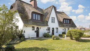 A traditional white house with thatched roofs and a small garden. - Süderwind 2 - Süderwind 2 - Komplett Renoviertes Mittelhausteil Über 3 Ebenen (Sylt-Ost)