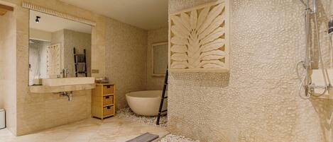 A bathroom with a bathtub, a shower, and a sink.