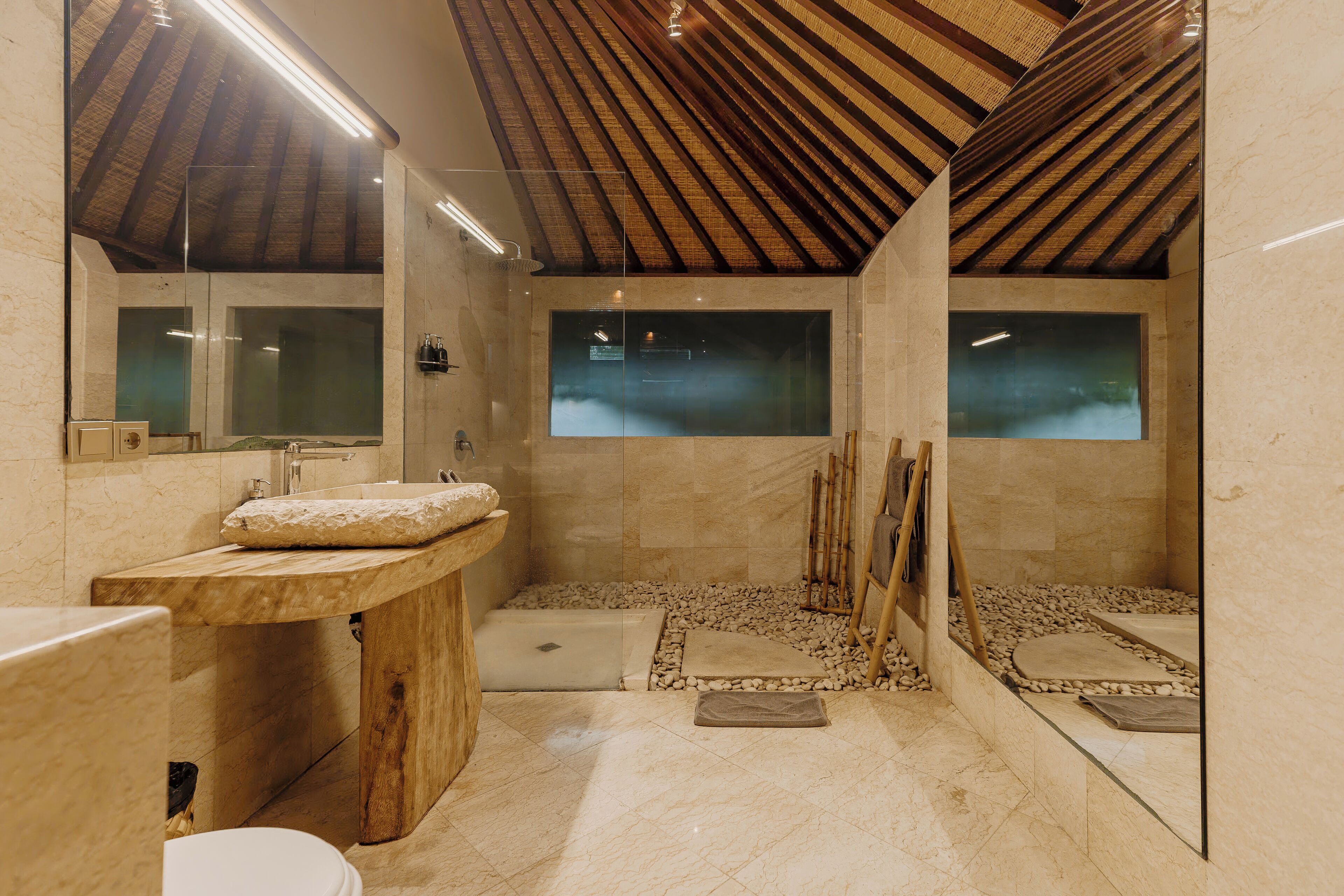 Une salle de bain avec un meuble-lavabo en bois, une baignoire et un espace douche.