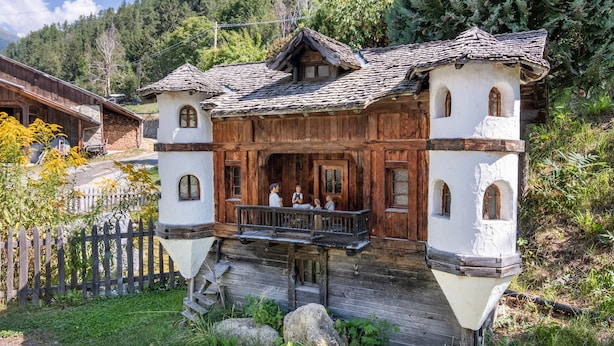 A traditional wooden chalet with a balcony, a stone staircase, and a view of the surrounding forest. - Apartment 'Patztauhof Tartscher Bühel' with Mountain View, Private Terrace and Wi-Fi (Sluderno BZ)