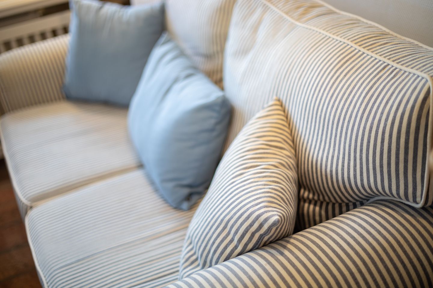 A striped sofa with two pillows.