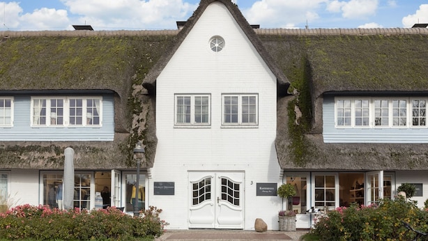 Il s’agit d’un bâtiment traditionnel, doté d’un toit à forte pente, de murs extérieurs blancs et d’une entrée centrale avec une double porte.