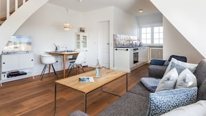Un appartement moderne comprenant un coin repas, une cuisine et un salon.