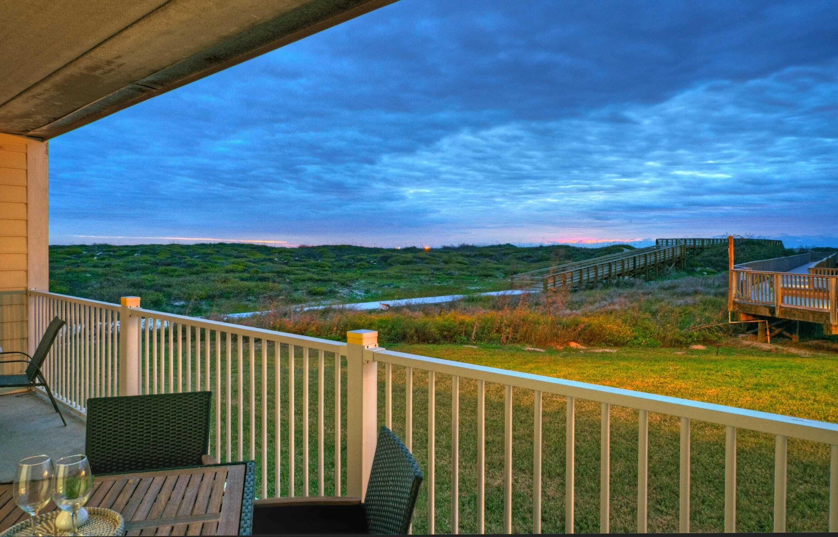 Un balcon donnant sur un paysage verdoyant et une terrasse en bois.