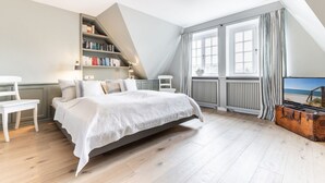 Una camera da letto con un letto, una libreria, una scrivania e una finestra con tende.