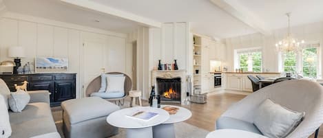 A spacious living room with a fireplace, a dining area, and a kitchen.