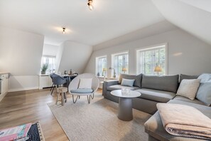 Ein modernes Loft-Apartment mit Essbereich, einer Sofagarnitur und einer Küche.