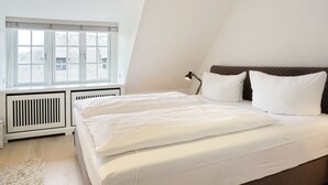 Una camera da letto con un letto, una finestra e un termosifone.