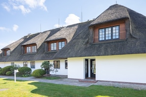 Une rangée de charmantes maisons traditionnelles aux toits de chaume, aux murs blancs et aux fenêtres en bois.