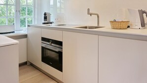 Una cucina moderna con forno integrato, lavello e macchina per il caffè.