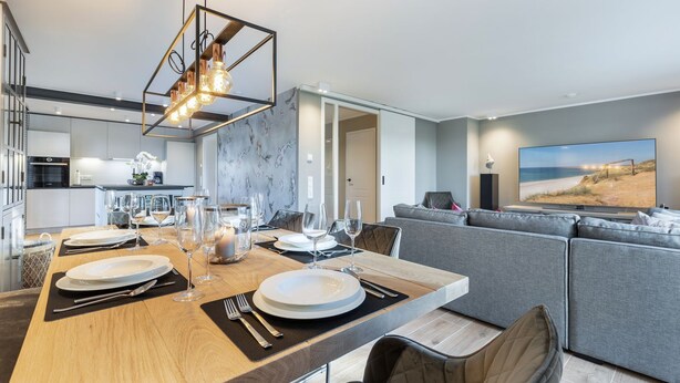 Une cuisine moderne avec un coin repas, un grand téléviseur à écran plat et un coin salon confortable.