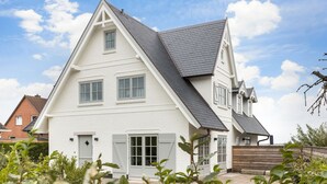 A two-story house with a gabled roof, a front door, and a garage.