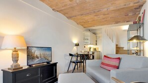 A modern living room with a TV, sofa, and dining area. - Kleine Heimat, Haus Stutenhof Whg. 4 - Die Kleine Heimat Befindet Sich im Herzen von Keitum und (Sylt)