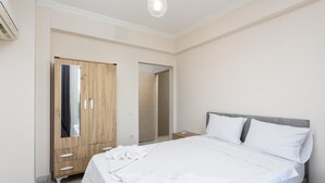 A hotel room with a bed, a wardrobe, a mirror, and a ceiling light. - Villa Azalea 1 in Ortaca (Ortaca)