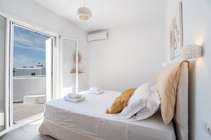 A bedroom with a bed, a window, and an air conditioning unit.
