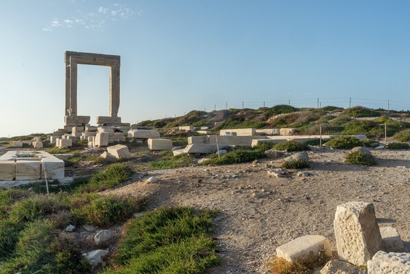 Ancient ruins with stone structures and a large archway.