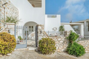 A modern building with stone walls, a metal gate, and a staircase leading to an entrance.