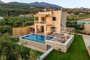 A two-story stone house with a swimming pool, a balcony, and a view of the surrounding hills. - Villa Nora in Ditiki Mani (West Mani)
