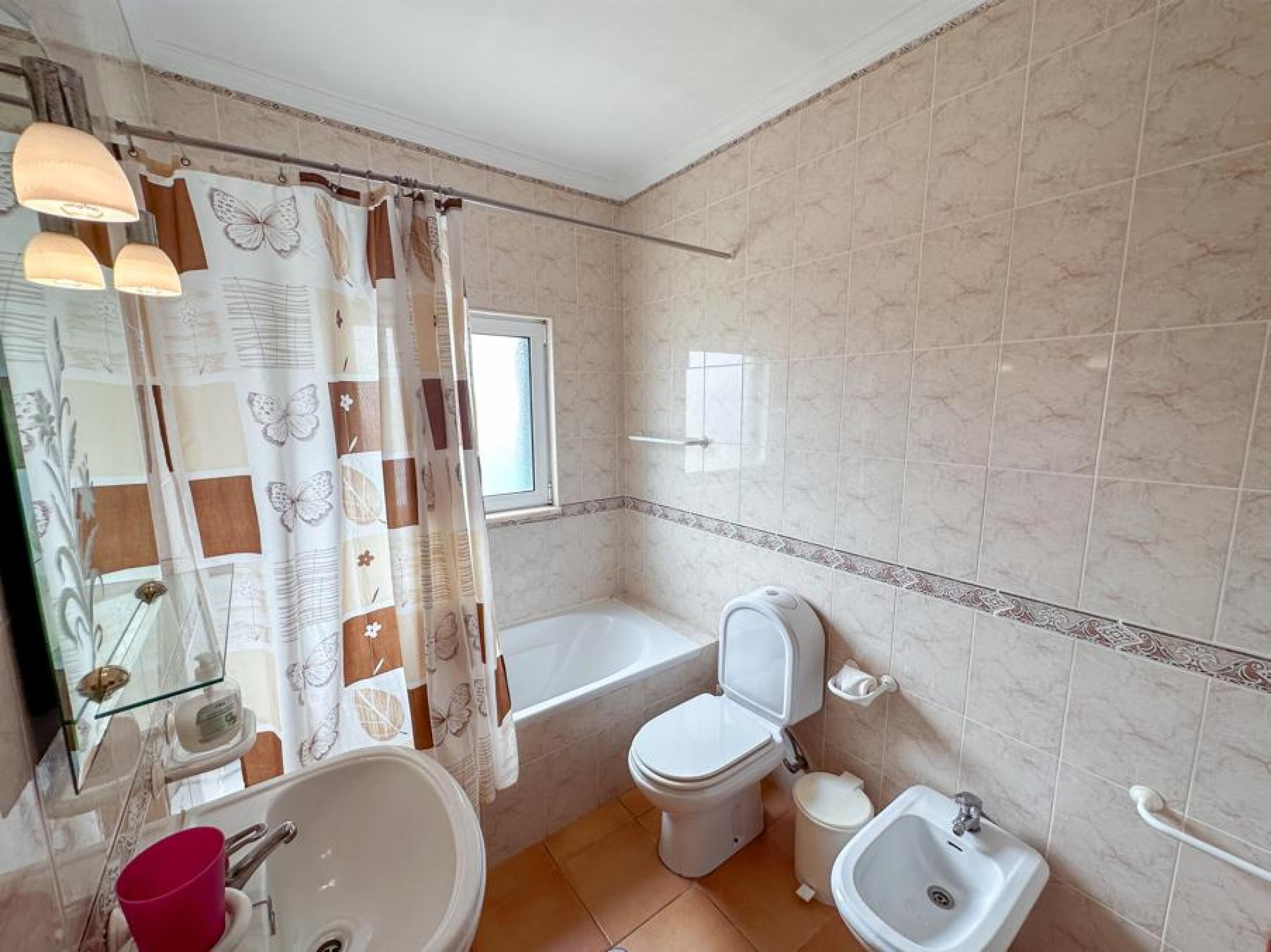 A bathroom with a bathtub, toilet, bidet, and sink.