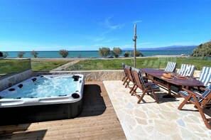 Relax in the hot tub with breathtaking views of the sea and distant mountains.