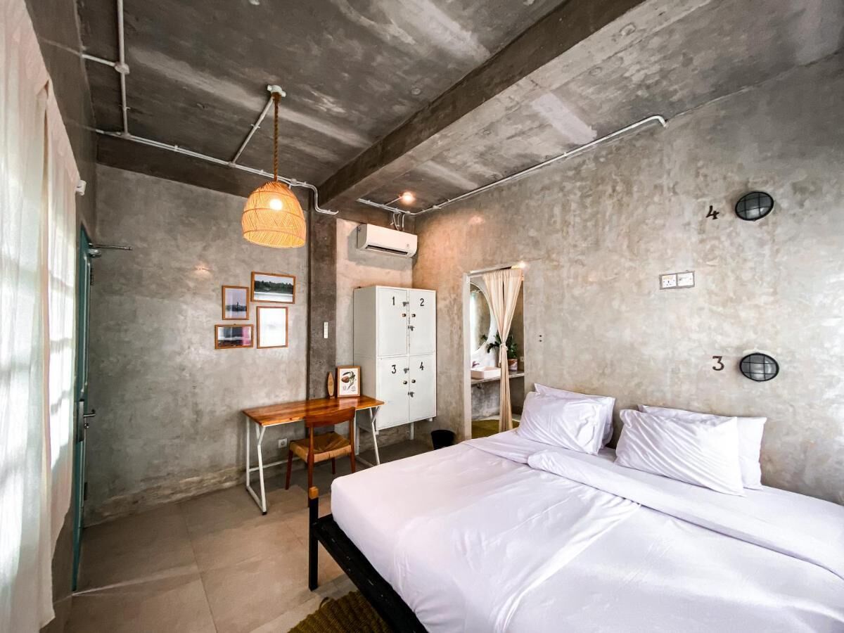 A bedroom with a bed, a desk, and a wardrobe.